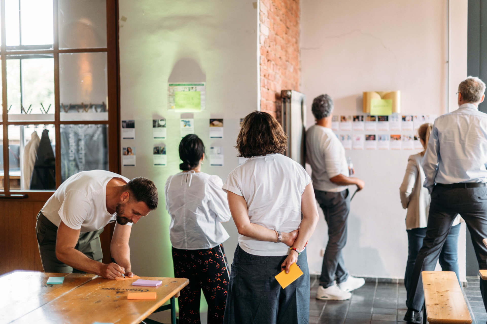 Workshop-Situation bei TheVentury mit Team an Pinnwand und Tisch